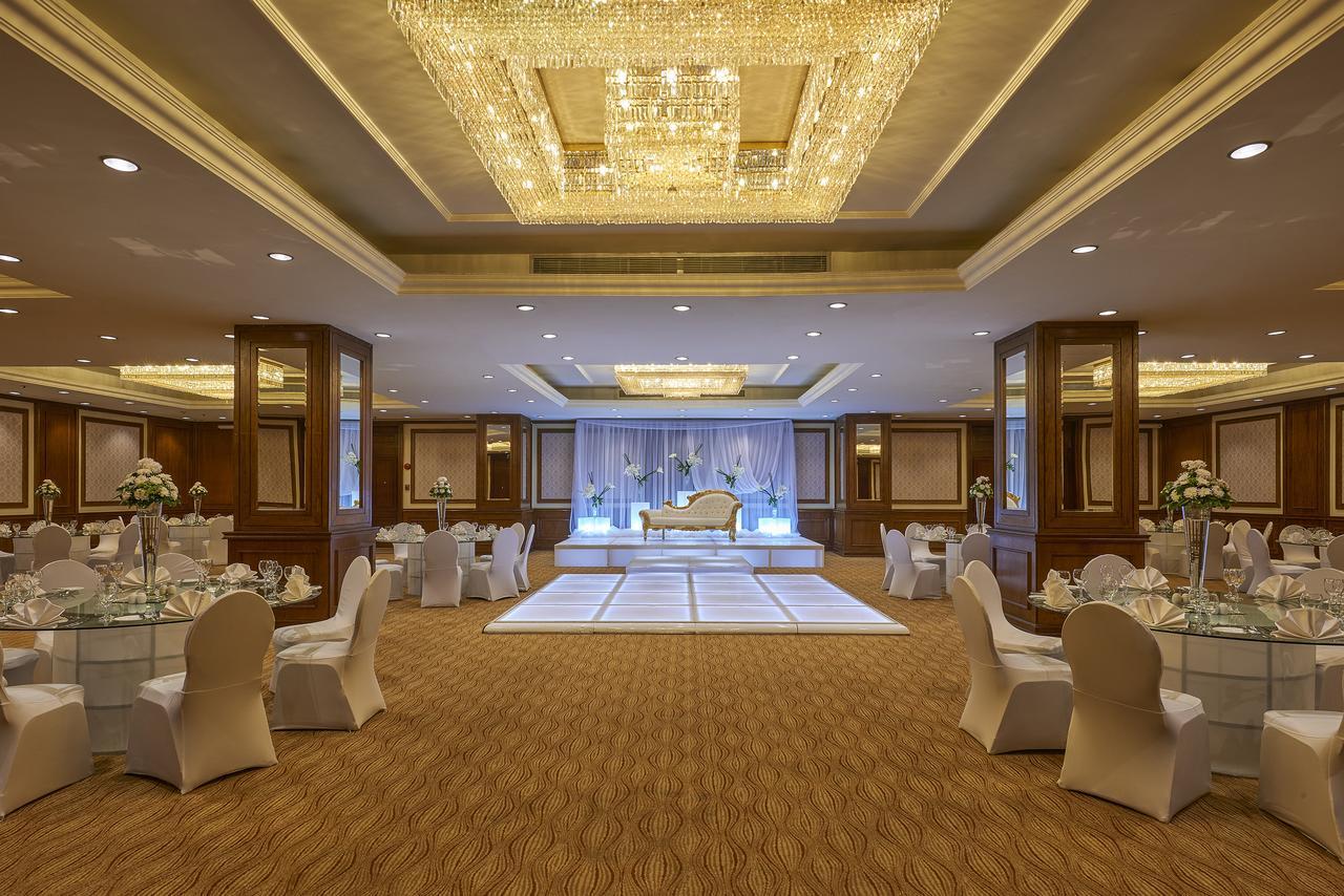 Safir Hotel Cairo Giza Екстериор снимка The photo shows an elegantly decorated event space. The room features a beautiful chandelier hanging from the ceiling, providing a warm glow. In the center, there is a raised platform that appears to be set up for a ceremony or celebration. Surroundi